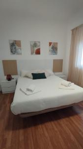 a bedroom with a large white bed and wooden floors at Apartamento Premium con 4 dormitorios y aire acondicionado in Albacete
