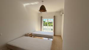 een kleine kamer met twee bedden en een raam bij BS House - Manta Rota in Manta Rota +27 foto's