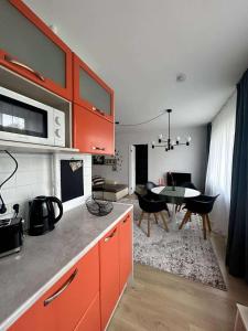 a kitchen with orange cabinets and a dining room at Your Place in Tallinn - newly renovated! in Tallinn