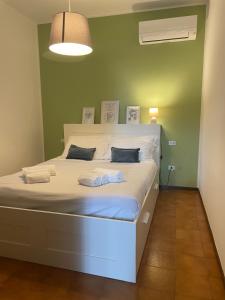a large bed in a room with a green wall at Bnbook - La casa sul Lago Maggiore in Ispra