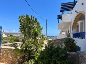 a white house with trees and plants in front of it at Diakofti Loft - Sea Breeze in Kythira