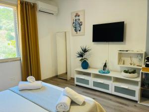 a bedroom with a bed and a tv on the wall at inKanto Room in Cefalù