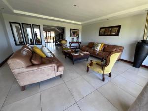 a living room with leather couches and chairs at Kalashe Bed & Breakfast in East London