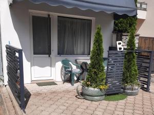 a house with a porch with a chair and a door at Stan na dan Break in Bačka Palanka