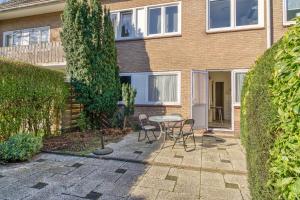 a patio with a table and chairs in front of a house at Appartement in Cadzand