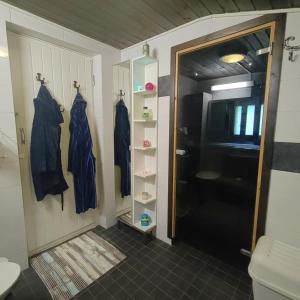 a bathroom with a black door and a toilet and towels at Piha-aitta taajamassa in Parikkala +31 photos