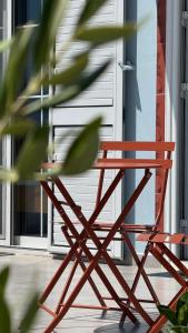 a red chair sitting in front of a door at Vila Bedro in Sarandë