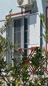an open window with a shutter on a house at Vila Bedro in Sarandë