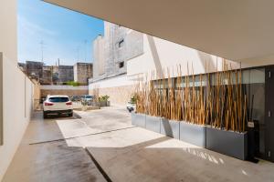 a building with a car parked in a parking lot at Glass House - Smart Rooms & Parking in Lecce