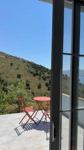 a table and chairs sitting on a patio with a window at Vila Bedro in Sarandë