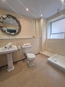 a bathroom with a toilet and a sink and a mirror at RainHill Hall Hotel in Rainhull +88 photos