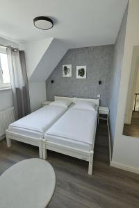 a bedroom with two white beds in a room at Ein zimmer Apartment in Dormagen