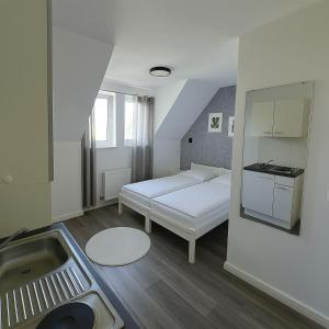 a bedroom with a white bed and a sink at Ein zimmer Apartment in Dormagen