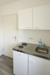 a kitchen with a stove and a sink at Ein zimmer Apartment in Dormagen