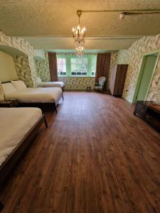 a large room with two beds and a chandelier at RainHill Hall Hotel in Rainhull