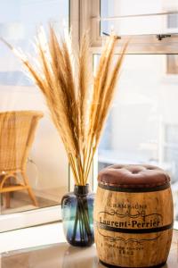 a vase with wheat spikes in it next to a window at Ocean Dream Sunset Sails in Swakopmund