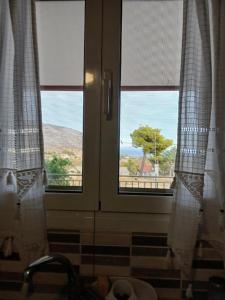 a window in a bathroom with a view of a tree at Marry's Guesthouse in Kineta +29 photos