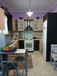 a kitchen with a table with a plate of fruit on it at Marry's Guesthouse in Kineta