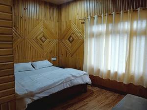 a bedroom with a bed with a wooden wall at Hotel Vishal & Restaurant in Munsyari
