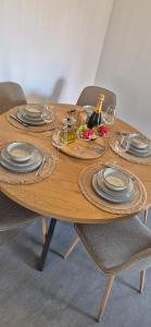a wooden table with plates and wine glasses on it at Blue Amber-Los Arenales del Sol-Alicante in Arenales del Sol