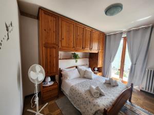 a bedroom with a bed with wooden cabinets and a window at Appartamento L'ulivo 5 chilometri da Varenna vista lago in via privata in Lierna +45 photos