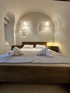 a bedroom with a large bed with two towels on it at Arch Residence, studio 1, Apothika in Katarráktis