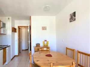 a kitchen with a wooden table in a room at Joli 2 pièces rénové avec balcon, au pied des pistes, pour 4 personnes, La Joue du Loup - FR-1-504-524 in Le Dévoluy