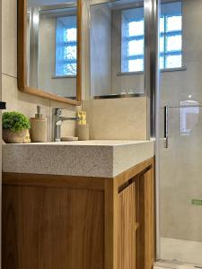 a bathroom with a sink and a mirror and a shower at Arch Residence, studio 1, Apothika in Katarráktis