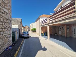 a car parked on a street between two buildings at Apartman Prgin in Primošten
