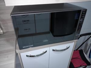 a microwave oven sitting on top of a cabinet at Caruaru com Melhor Custo-Benefício in Caruaru