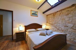 Un dormitorio con una cama y una pared de piedra. en Antique apartment Arsenale, en Rovinj