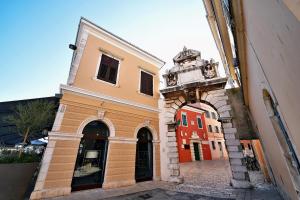 un edificio con un arco junto a un edificio en Antique apartment Arsenale, en Rovinj
