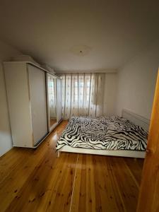 a zebra print bed in a room with wooden floors at Lankaran house in Lankaran