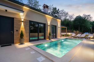 een zwembad in de achtertuin van een huis bij Charming Villa Harmonia with Heated pool and Indoor Jacuzzi surrounded by nature in Pićan