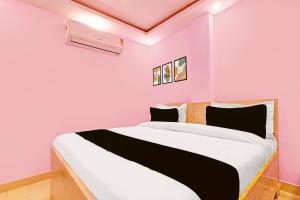 1 dormitorio con paredes rosas y 1 cama grande en Hotel O Sky House Residency, en Nueva Delhi