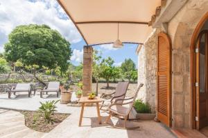 un patio al aire libre con sillas, mesa y árboles en Can Bisquerra, en Pollensa