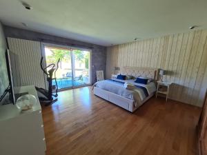 La BredeにあるLa Bredi Villa proche de Bordeaux avec piscine et spaのベッドとガラスの引き戸のある寝室 +18枚の写真