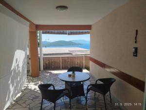 a patio with a table and chairs and a window at Apartmani - sobe Ćosić in Neum