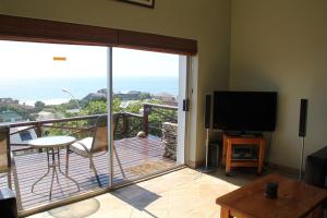 a living room with a balcony with a sliding glass door at Surf View in Jeffreys Bay