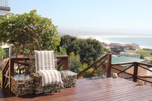 a pair of chairs sitting on a deck overlooking the ocean at Surf View in Jeffreys Bay