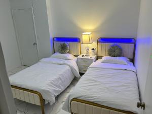 two beds in a small room with a lamp on a table at CampRV Main Lodge in Elkins