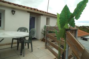 a patio with a table and chairs on a balcony at La passerose in Champagné-les-Marais