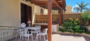 a patio with a table and chairs on a balcony at Il Mare nel Cuore in Custonaci