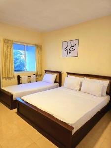 ハプタレーにあるBlackwood Hotelのベッド2台と窓のある寝室