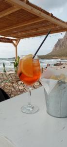 a drink sitting on a table next to the beach at Il Mare nel Cuore in Custonaci