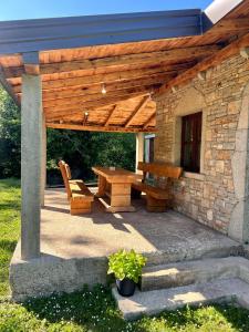 a wooden pavilion with a table and a bench at Konoba DB in Čapljina