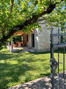 a brick house with a gate in a yard at Konoba DB in Čapljina