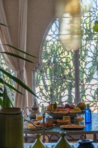 un tavolo con piatti di cibo sopra con una finestra di Dar Mogador Sun near Taghazout - Surf, Sea, colorful village a Taghazout Altre 45 foto