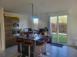 a kitchen with a island in the middle of a room at Chambre d'hôtes Goustranville in Goustranville