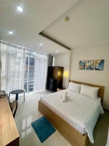 Un dormitorio con una cama grande y una ventana grande. en Atusy Boutique Hotel, en Ho Chi Minh